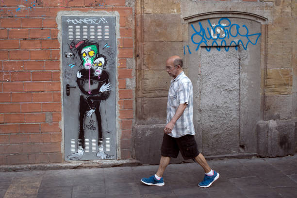 barcelona spain july -8- 205-   a man walks beside a house wall with a fun painting in Spain the figures on the door are afraid of something