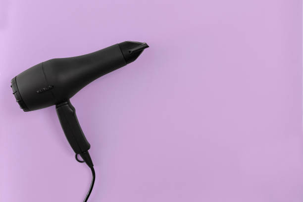 istock Black hair dryer on lilac paper background 845927042