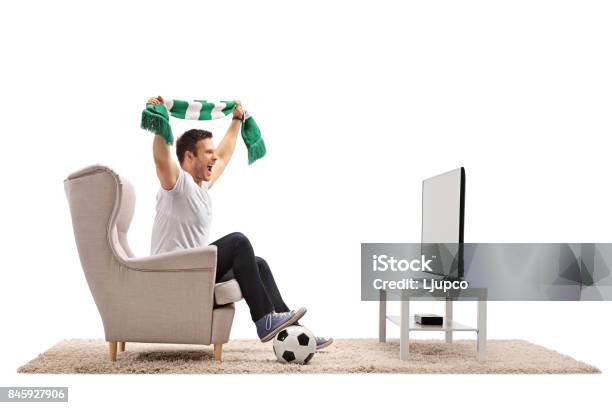 Ventilador De Fútbol Emocionado Con Una Bufanda Sentado En Un Sillón Foto de stock y más banco de imágenes de Aficionado