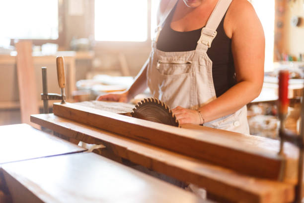 joinery Female carpenter operates circular saw - 
 fähigkeit stock pictures, royalty-free photos & images