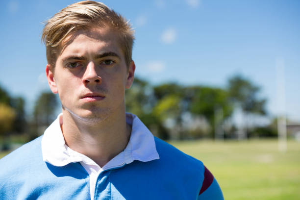 Portrait of rugby player standing at field