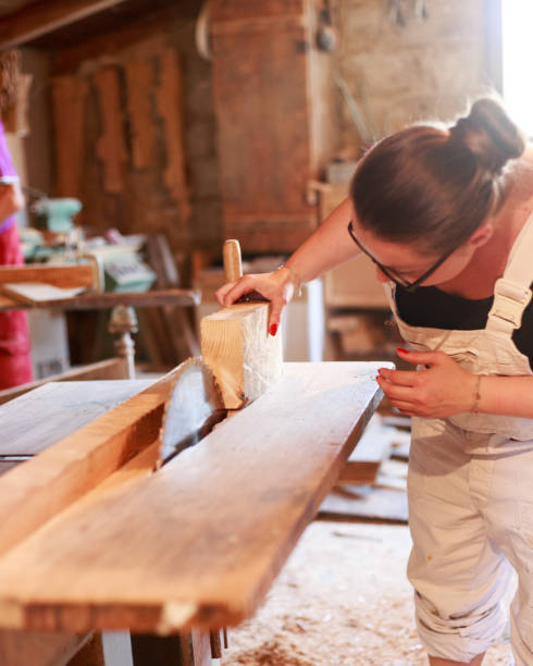 Tischlerin Carpenter with the circular saw - 
 fähigkeit stock pictures, royalty-free photos & images