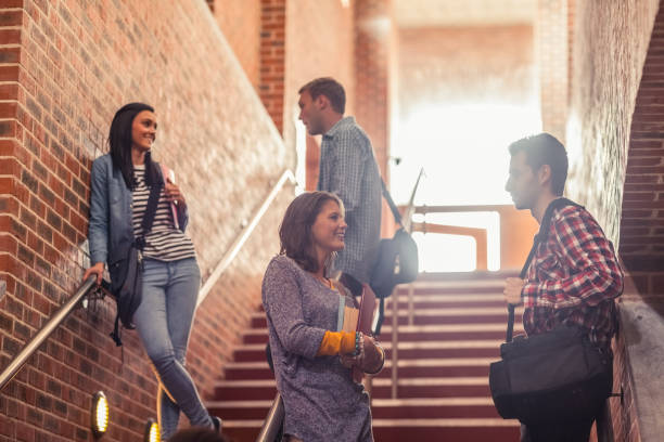 istock Casual students standing on stairs chatting 845939296