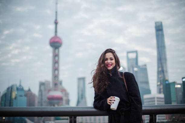Gorgeous woman with beautiful brown hair, having fun alone in the city on a cold and cloudy spring day.