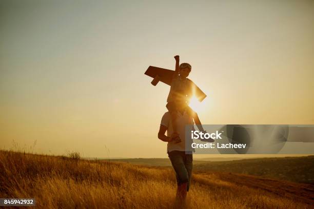 Vater Mit Seinem Sohn In Einem Pilotanzug Bei Sonnenuntergang In Der Natur Stockfoto und mehr Bilder von Pilot