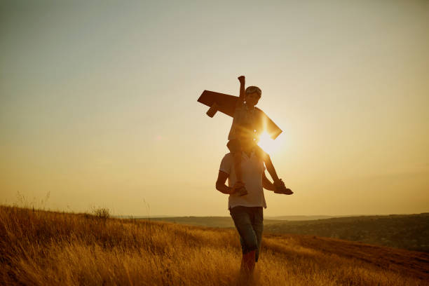 istock Dad with his son in a pilot's suit at sunset in nature. 845942932