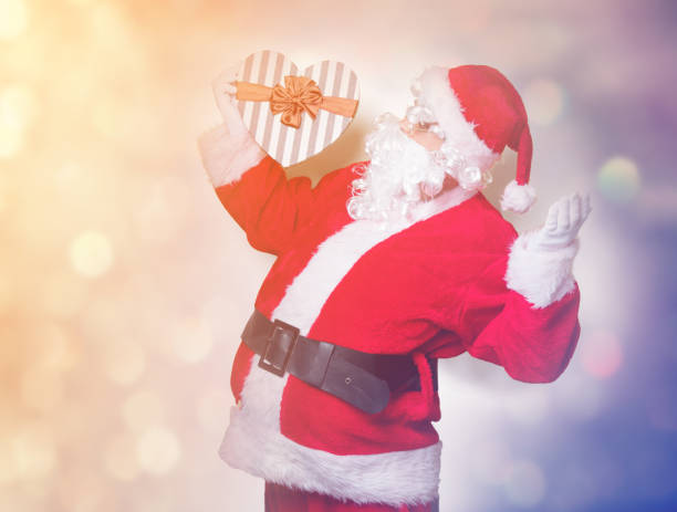 istock Funny Santa Claus holding heart shape gift 845946266