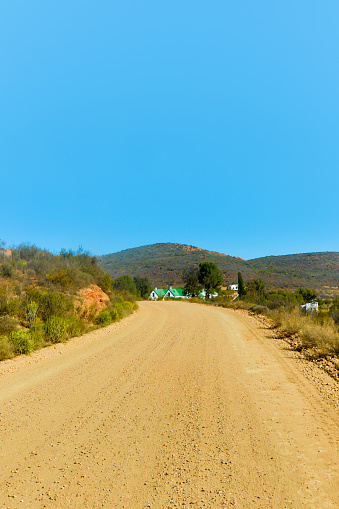 The dusty road to the town of Calitzdorp with blue skies.