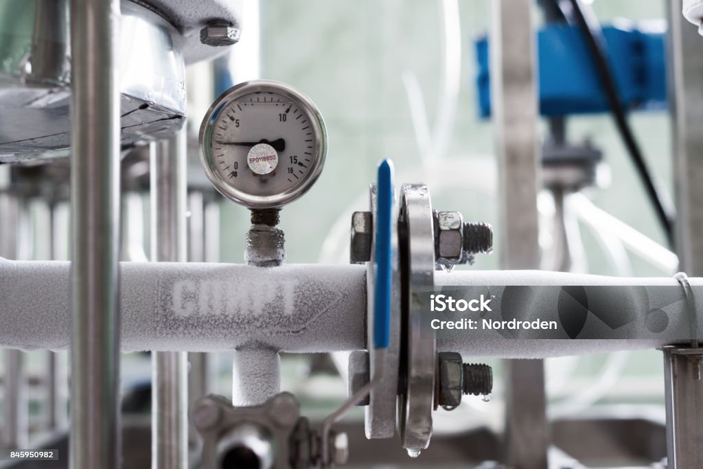 The pipeline is completely covered with hoarfrost The pipeline is completely covered with hoarfrost. Flanged pipe connection. Industry Stock Photo