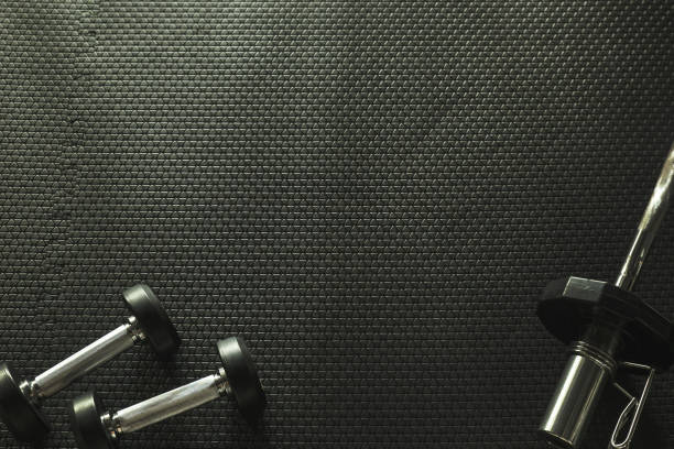 istock GYM background with Barbell and dumbbells on the floor with empty space 845966862