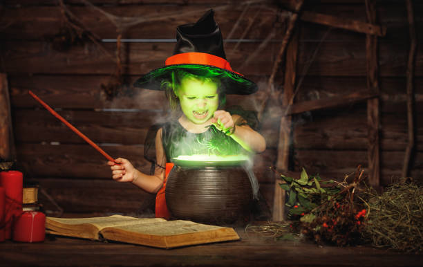 halloween. petit enfant sorcière potion dans le chaudron avec le grimoire de cuisine - 6729 photos et images de collection
