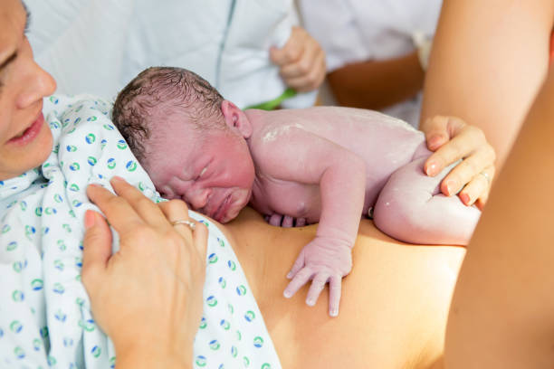 幸せなお母さん、赤ちゃん肌の皮膚に出生後の最初の秒を持っています。 - touching children only day europe ストックフォトと画像