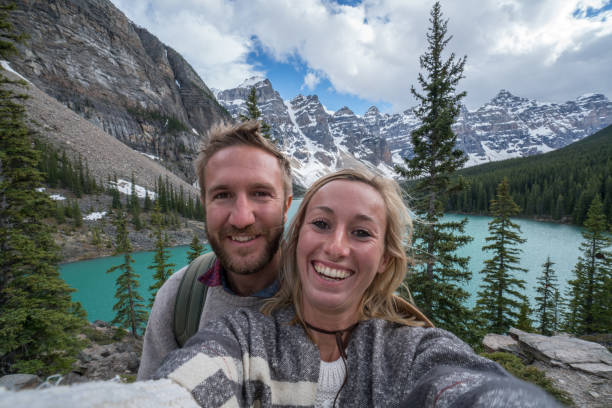 istock Two young adults taking selfie portrait at mountain lake 845977262