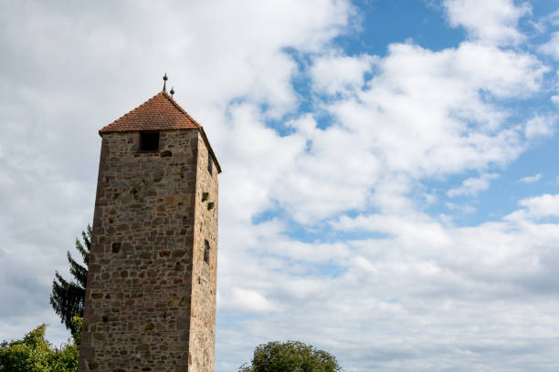 istock A medieval tower in front of blue sky and clouds 845979910