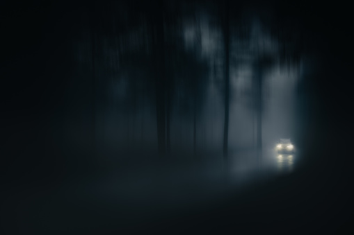 car in a country road with fog and low visibility. Blur added
