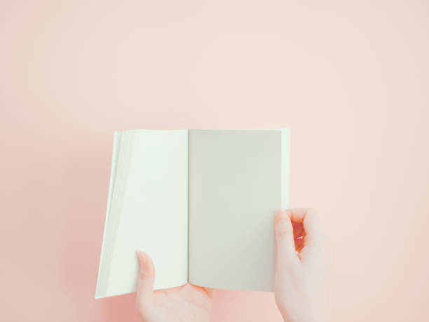 istock asian woman hold , open and present her new book or document display by both hand with pink pastel background 845984990