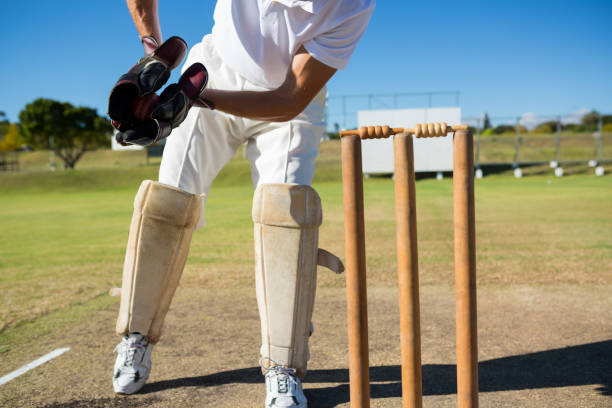 istock Low section of wicket keeper standing by stumps during match 845985148