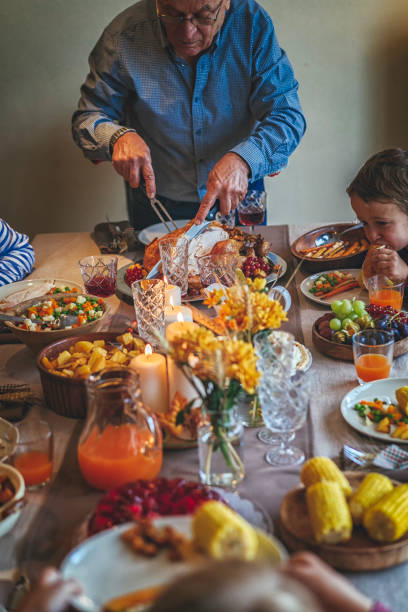 istock Grandfather Carving Stuffed Turkey for Holiday Dinner 845988488