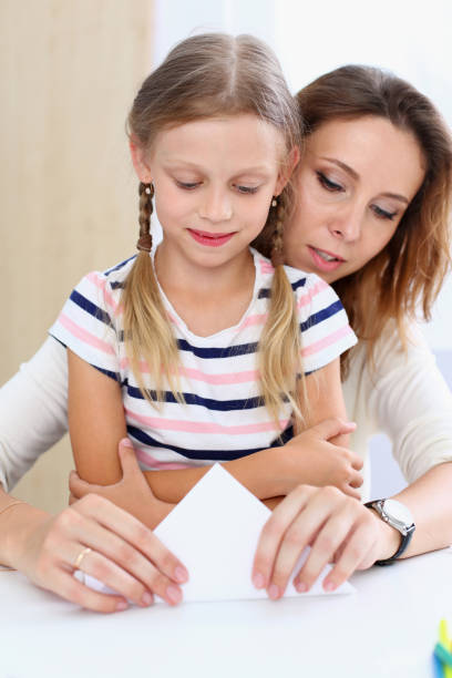 istock Blond smiling little girl make paper plane 845990518