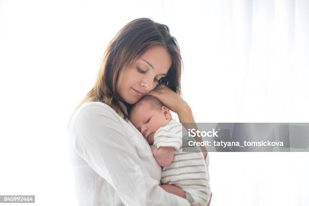 Joven Madre Con Su Bebé Recién Nacido Foto de stock y más banco de imágenes de Madre - Madre, Bebé, Recién nacido - 0-1 mes