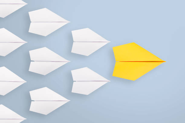 istock Leadership concepts with yellow paper plane leading among white 845992636