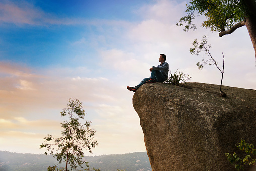 A man sitting on cliff enjoy the view