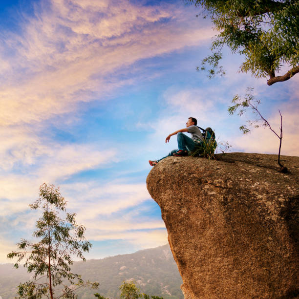 istock Hiking man sitting on cliff enjoy the view 846005828