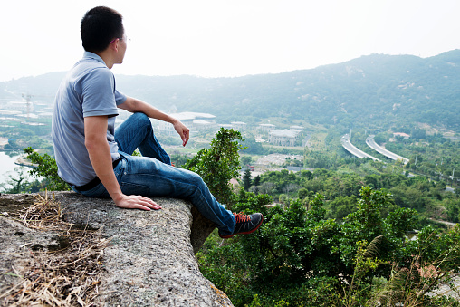 Man sitting at the edge of a cliff