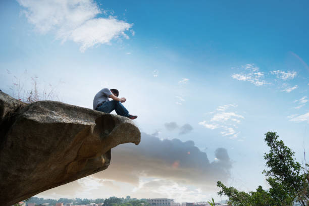 istock Man sitting at the edge of a cliff and thinking 846006980