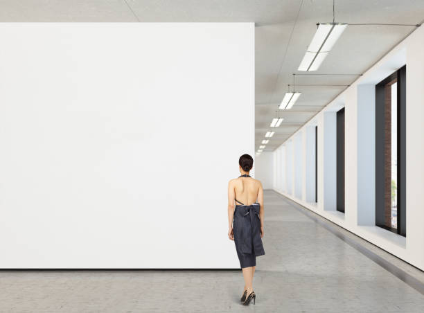 istock Woman looking at blank poster in modern gallery 846010378