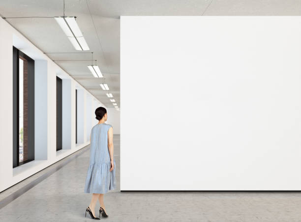istock Woman looking at blank poster in modern gallery 846010672