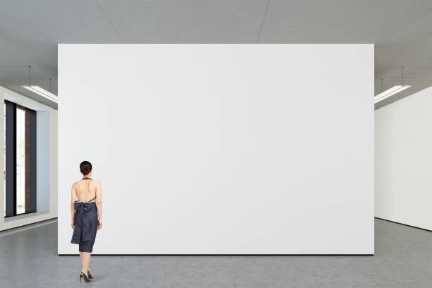 istock Woman looking at blank poster in modern gallery 846010774