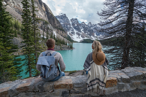Two young people enjoying the beautiful view of Moraine lake, Canada