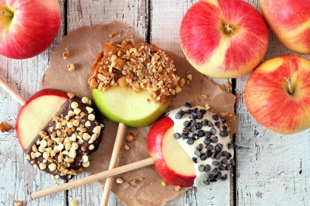 istock Apples rounds dipped with chocolate and caramel, above on white wood 846011836