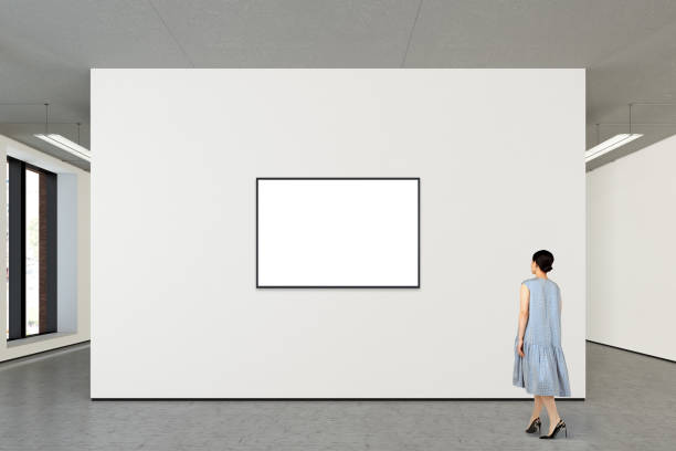 Woman looking at blank poster in modern gallery
