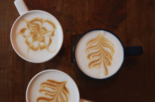 Latte art - three cups on coffee  with various design on dark wooden background
