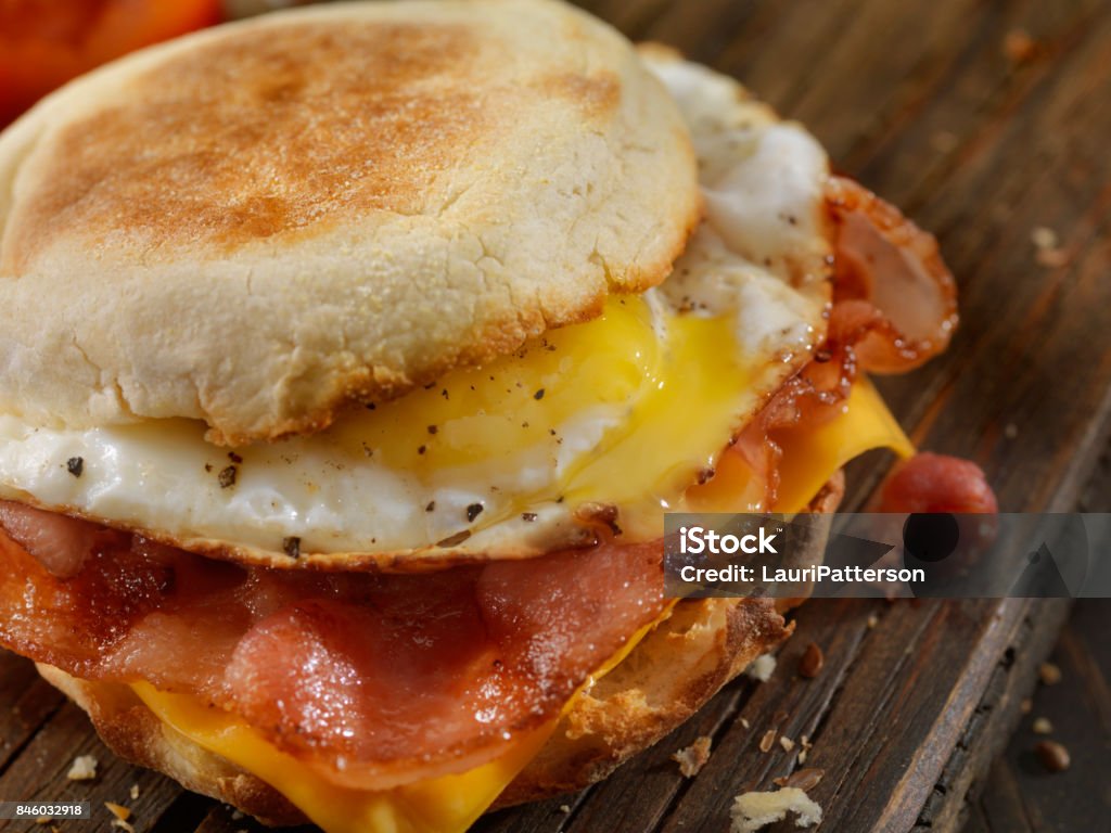 Panino per la colazione a base di pancetta, uova e formaggio - Foto stock royalty-free di Prima colazione