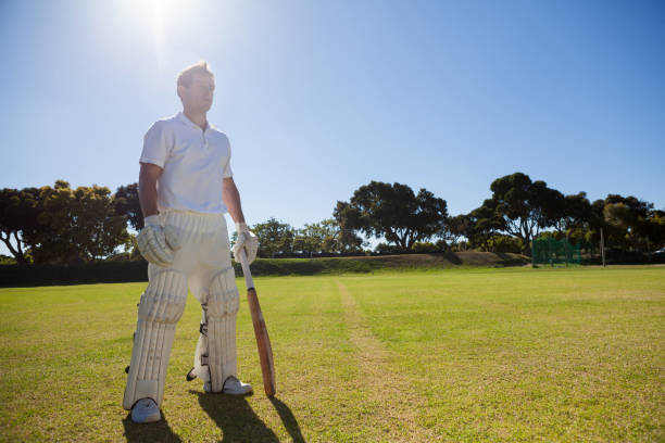istock Cricket player with bat standing on grassy field 846036904