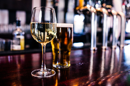 Close up of a glass of wine and a beer in a bar