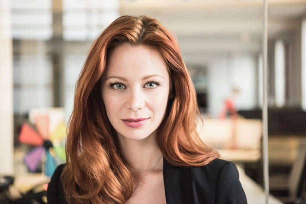 istock Red haired businesswoman looking at camera in modern office 846040830