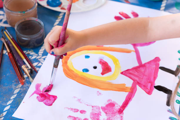 istock little girl having fun painting her hands 846047318