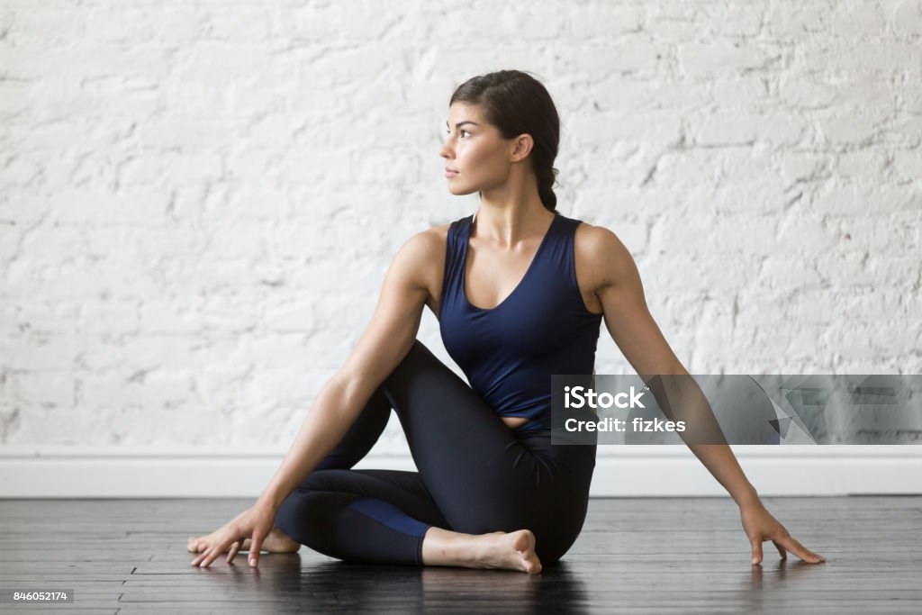 Junge attraktive Frau im Ardha Matsyendrasana darstellen, Studio-Hintergrund - Lizenzfrei Yoga Stock-Foto