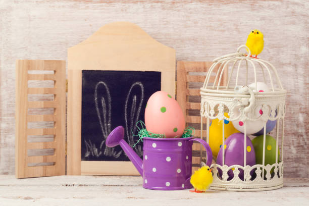 istock Easter holiday concept with egg decoration in bird cage over rustic background 846055482