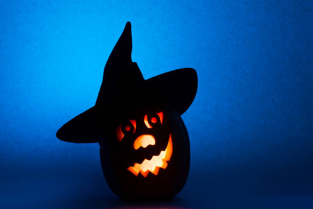istock Happy Halloween pumpkin in hat, funny face on blue background 846059538