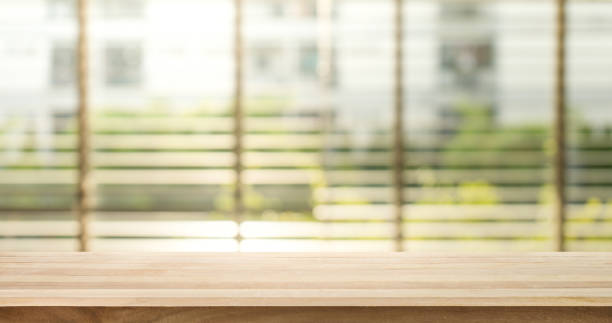 istock Wood table top with blur window shutters background 846059602