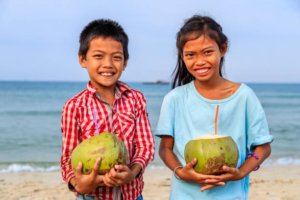 istock Cambodian children holding coconuts on the beach, Cambodia 846059624