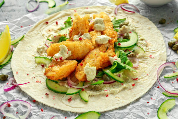 tortilla de pescado fresco con pepino, cebolla roja, alcaparras, limón, hojas de ensalada y salsa tártara. alimentos saludables - tuna salad sandwich fotografías e imágenes de stock