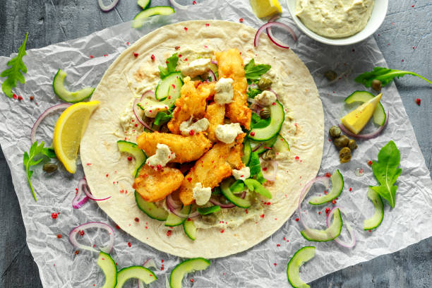 frischer fisch-tortilla mit gurke, roten zwiebeln, kapern, zitrone, salatblätter und sauce tartare. gesunde ernährung - tuna salad sandwich stock-fotos und bilder