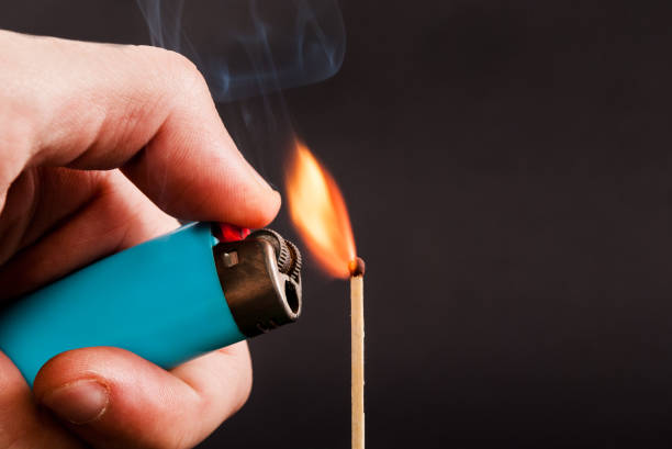 istock Male hand holding a lighter with flame and lights a match 846067816