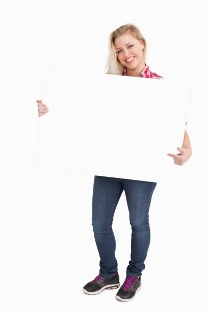 istock Blonde woman beaming while pointing at a placard 846068280